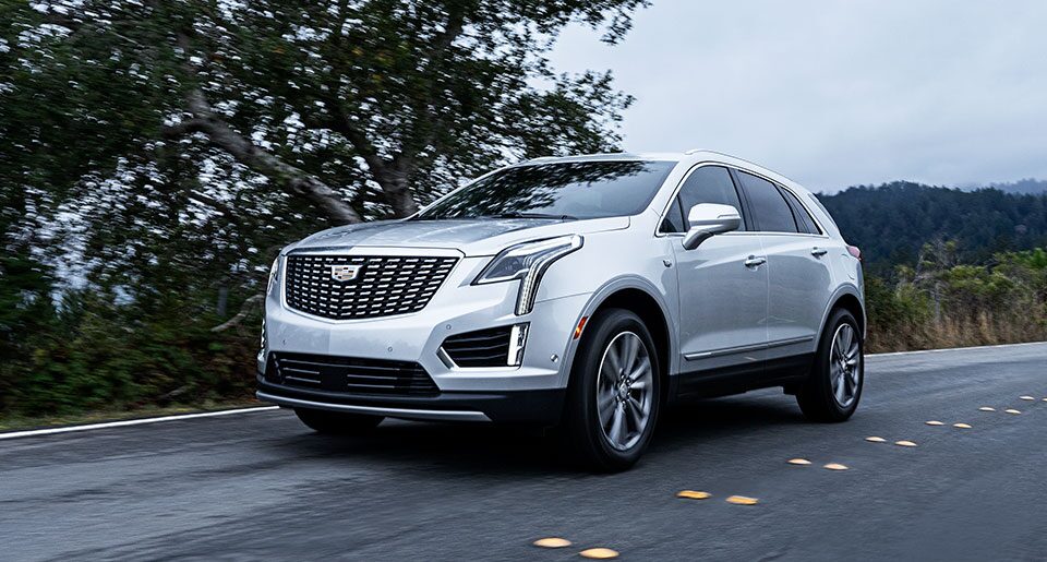 El Cadillac XT5 andando por un camino de montaña en un día nublado