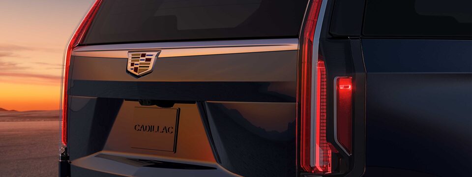 El elegante diseño de la parte trasera del Cadillac Escalade con una puesta de sol en un desierto como telón de fondo