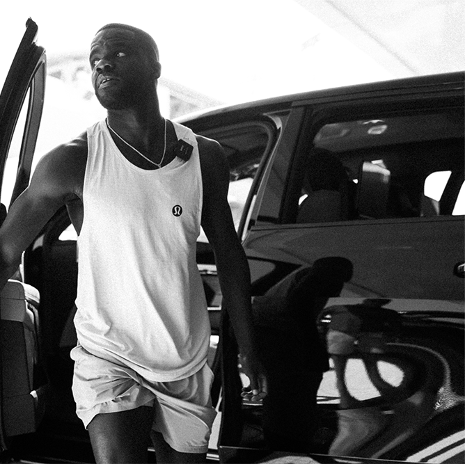 Frances Tiafoe Getting out of a Black Cadillac SUV in a Black and White Photo