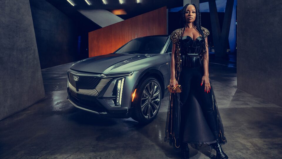 Goyo de pie frente a la SUV eléctrica Cadillac LYRIQ 2023