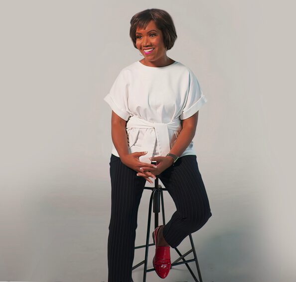 Crystal Windham Sitting on a Stool Smiling for the Camera