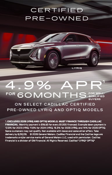 A multi-vehicle lineup of the Cadillac VISTIQ, LYRIQ, and OPTIQ parked on a paved stone driveway in front of a sunset