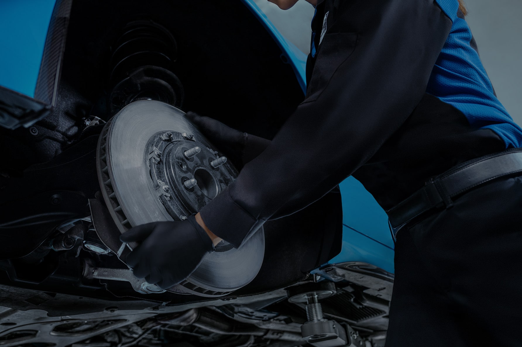 A Close Up of a Technician Working on the Brakes and Rotors of a Vehicle