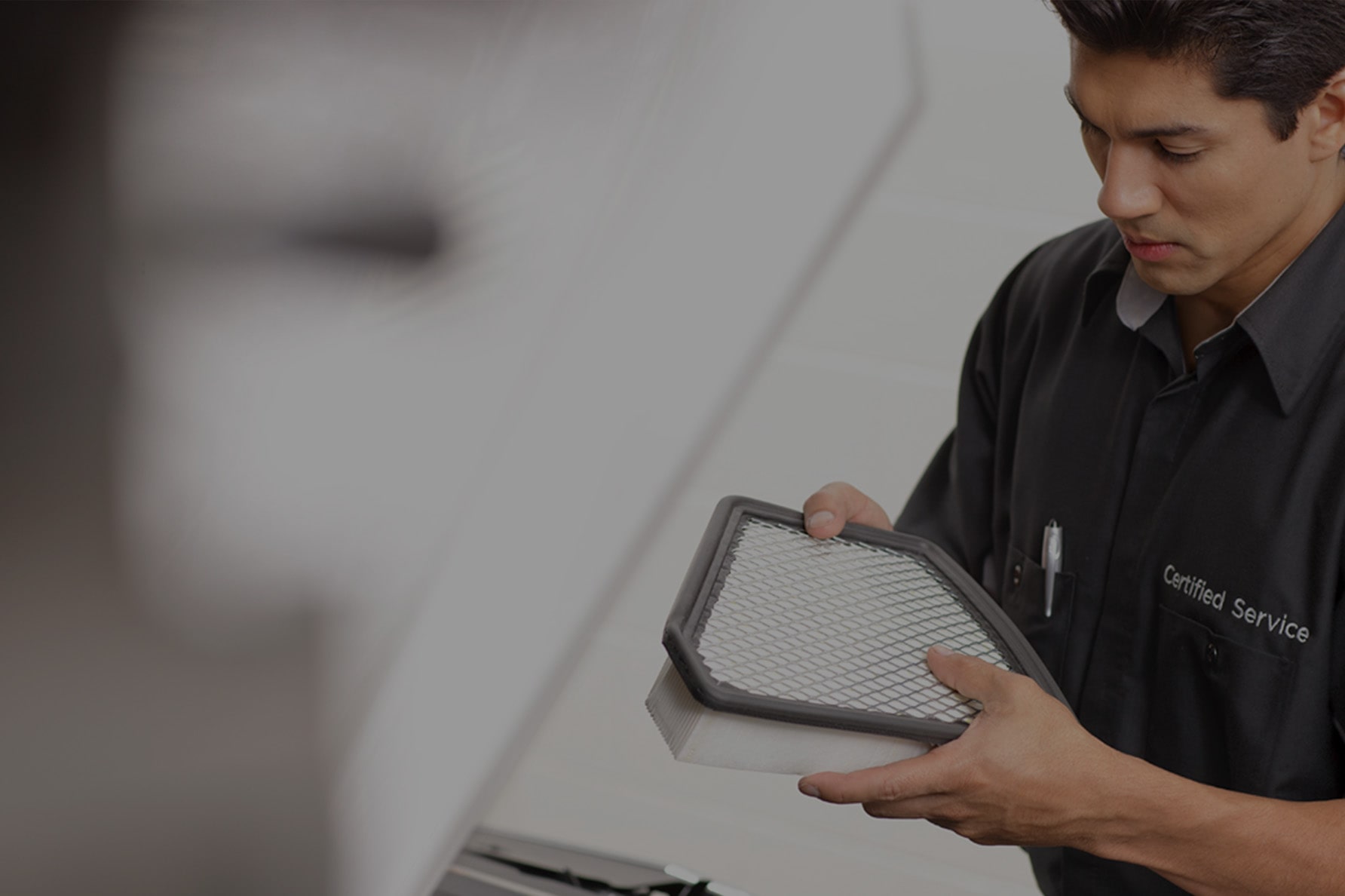 A Service Technician Inspecting a Filter of a Vehicle