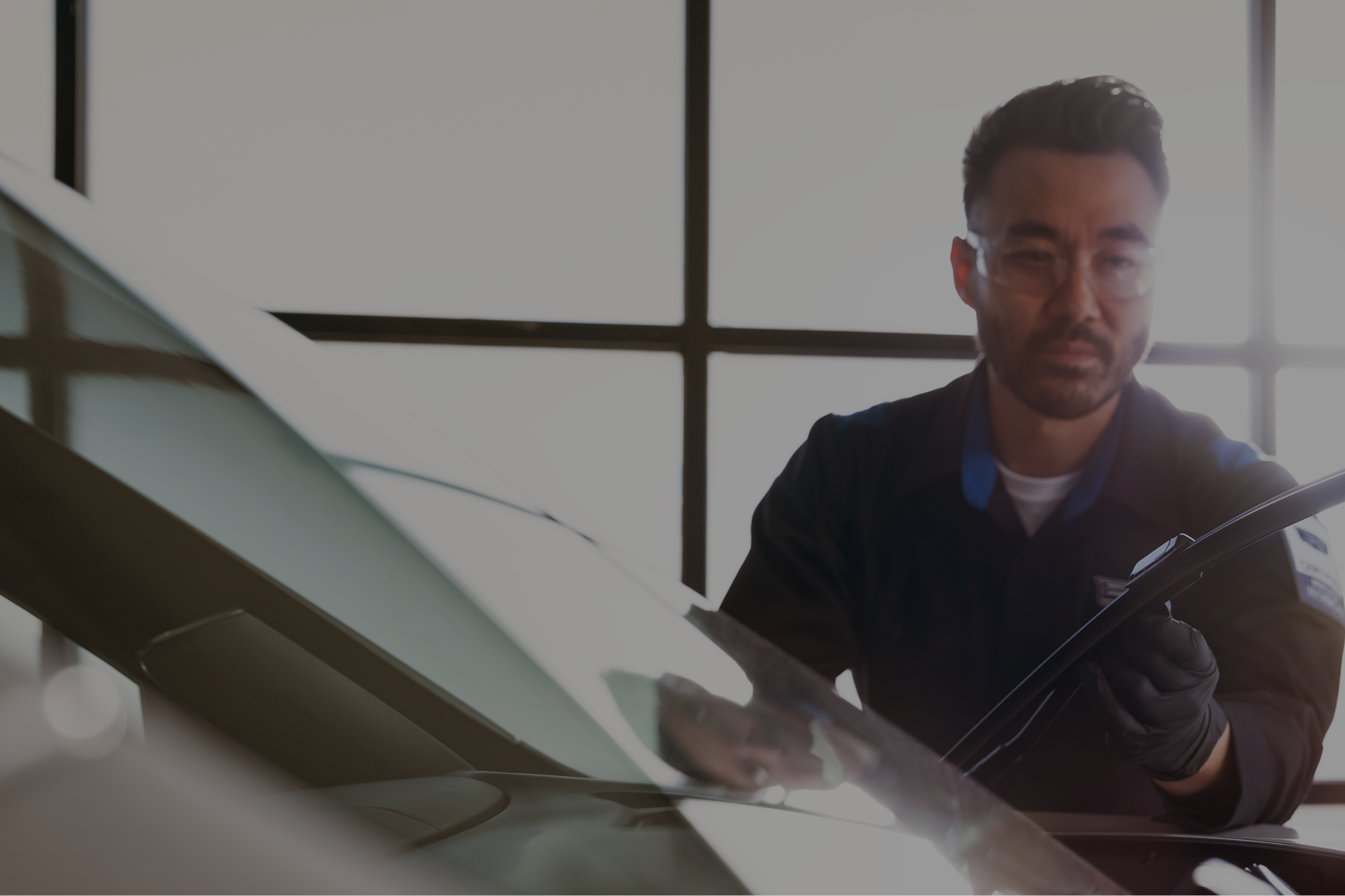A Service Technician Inspecting a Windshield Part of a Vehicle