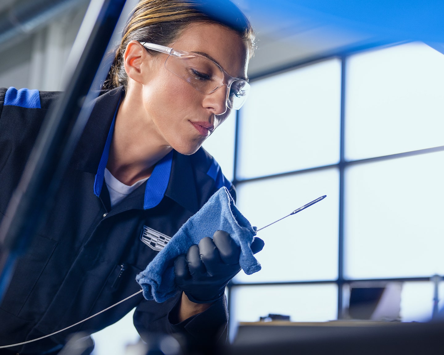 A Female Technician Inspecting a Stick from a Vehicle