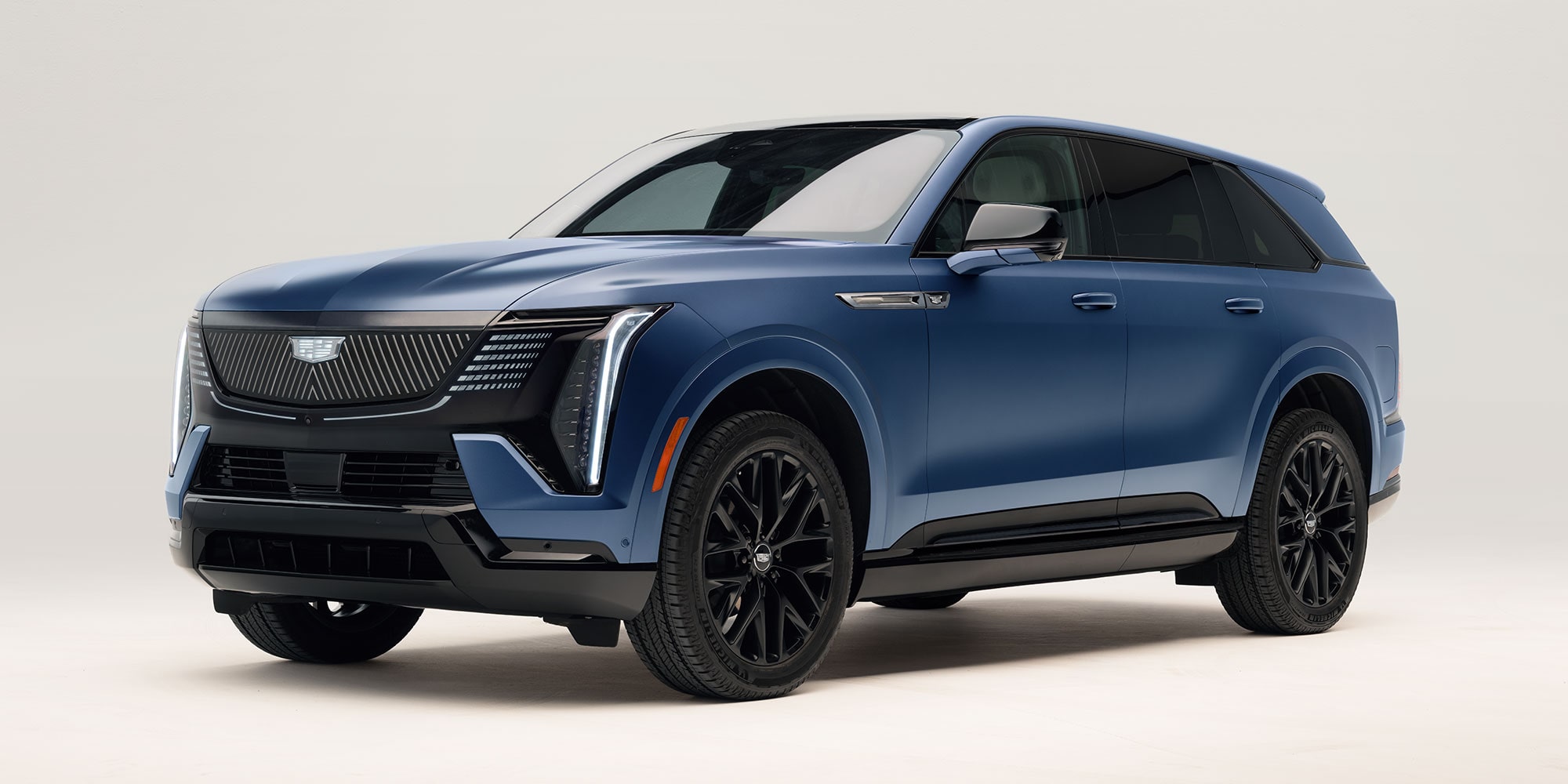 Primer plano del asiento de un vehículo Cadillac, donde se muestra el tapizado acolchado de colores claros con costuras complejas y laterales en cuero Marrón.