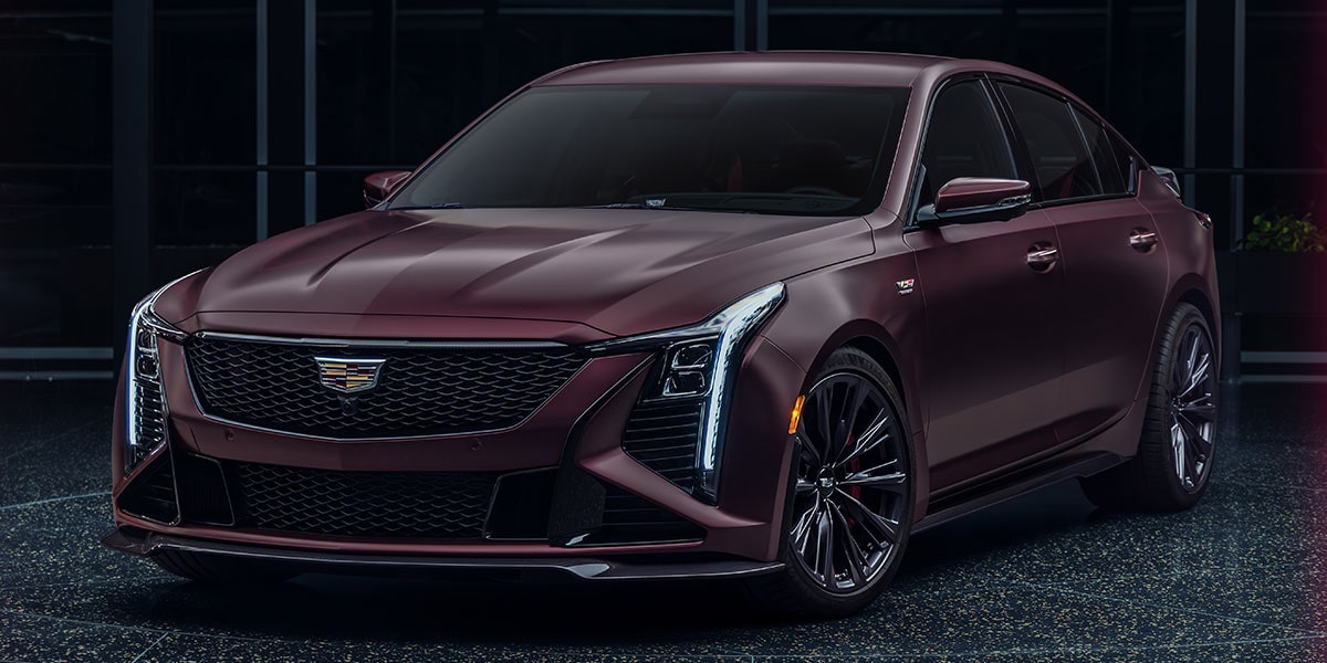 Three-quarter View of a Maroon Curated by Cadillac CT5-V Blackwing Parked in a Dark Showroom