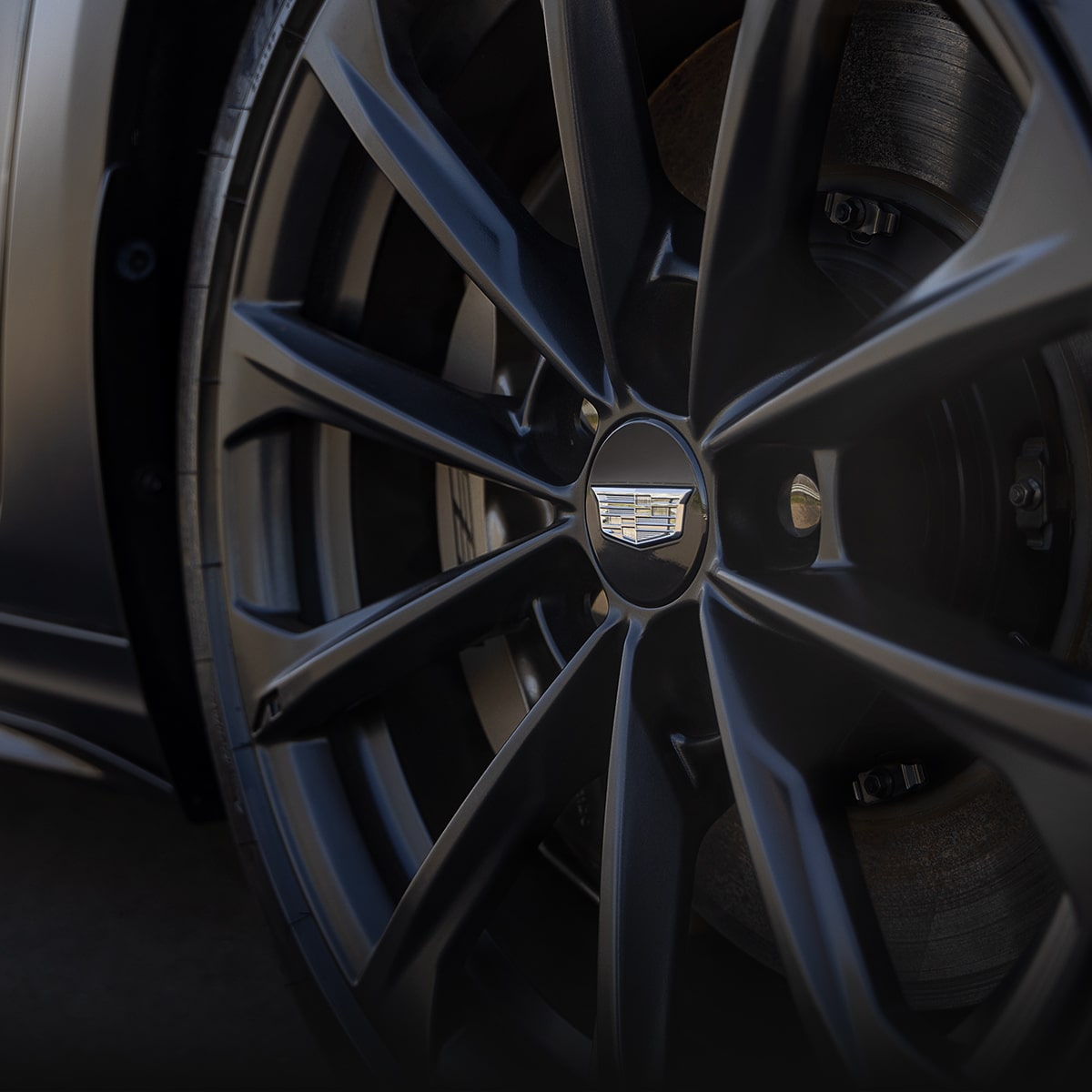 El icónico emblema de Cadillac en un neumático y rin en Negro sobre Negro