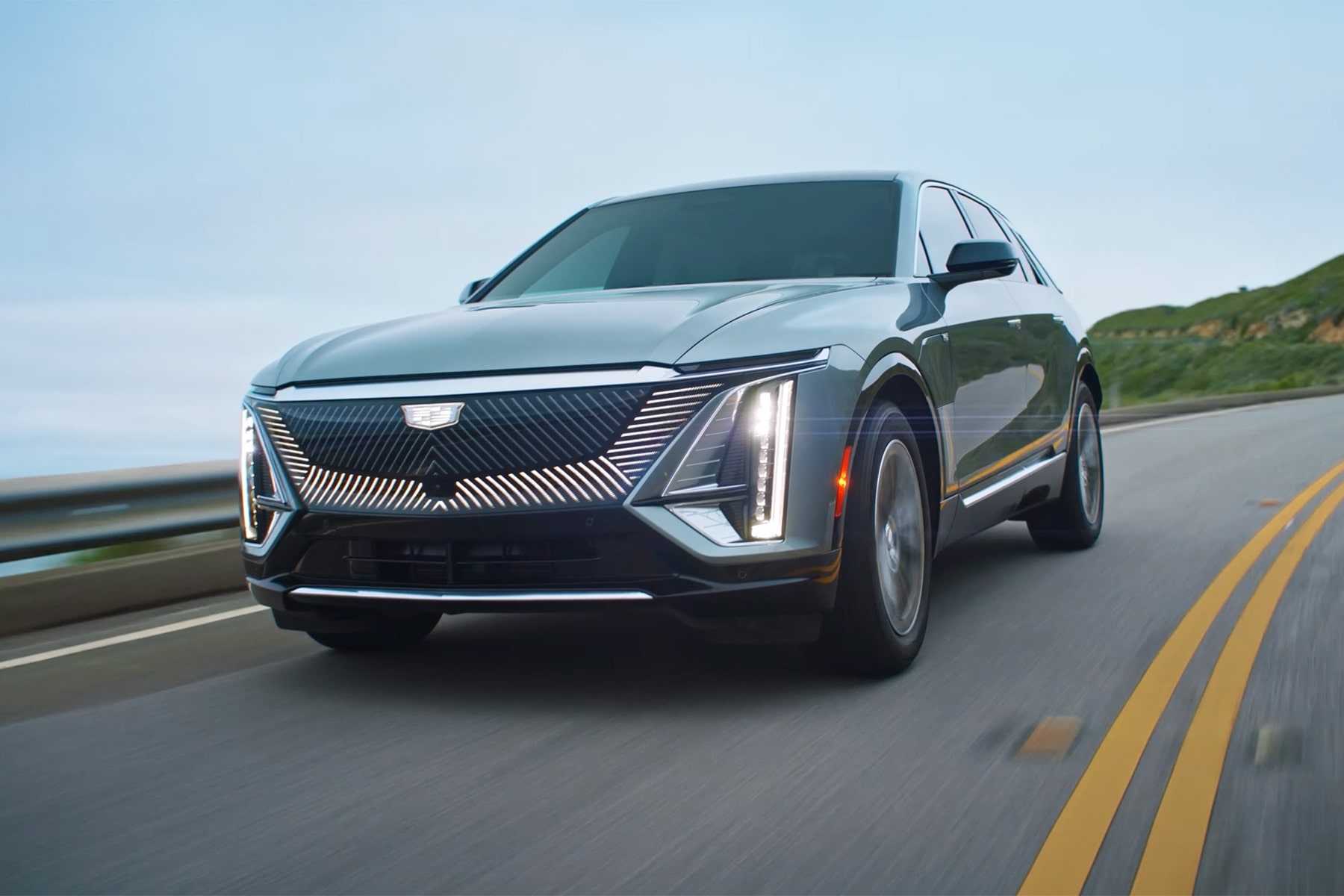 Silver 2027 Cadillac LYRIQ Driving on a Curved Road.