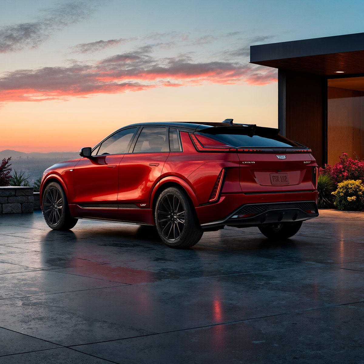 Vista de medio perfil trasera de Cadillac LYRIQ-V 2027 Roja estacionada afuera de una casa moderna al atardecer.