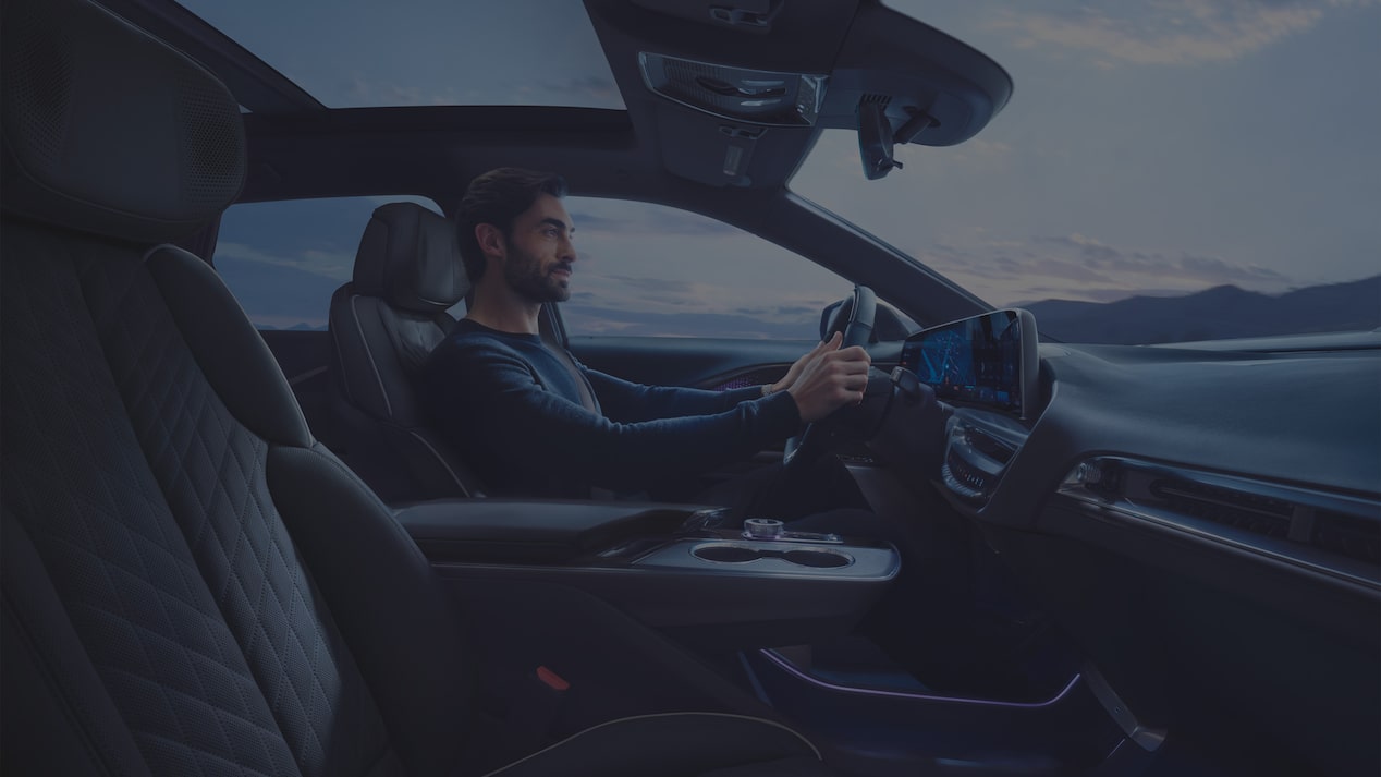 Driver Inside a 2027 Cadillac LYRIQ With a Panoramic Glass Roof and Interior Cabin Views.