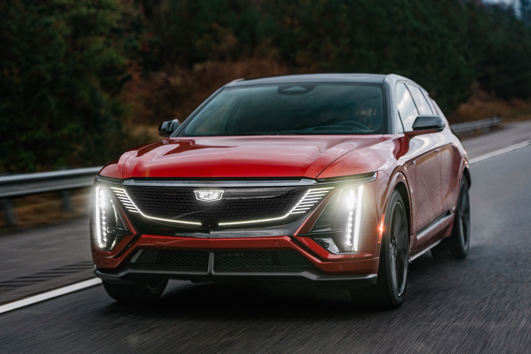 Front View of a Red 2027 Cadillac LYRIQ-V Driving on a Road.