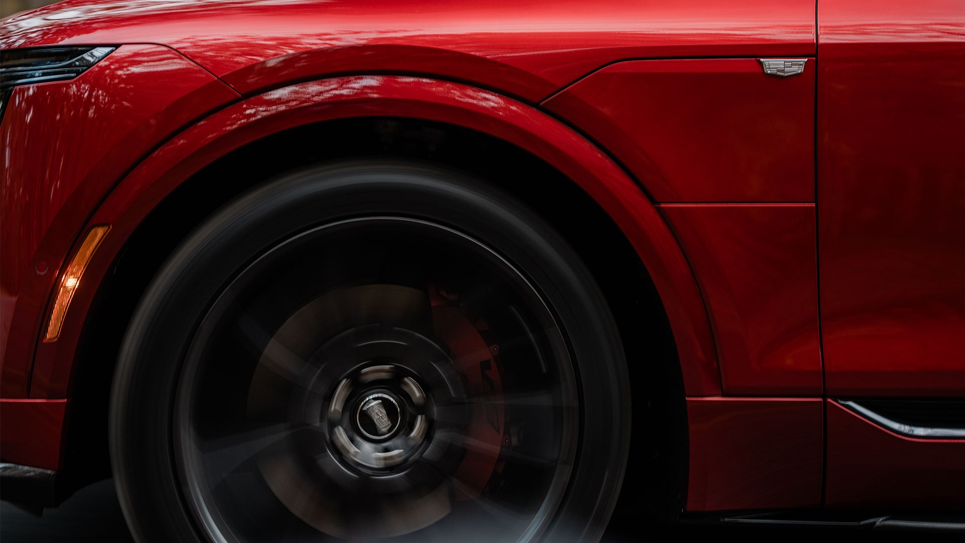 Front Wheel of a Red 2027 Cadillac LYRIQ-V in Motion.