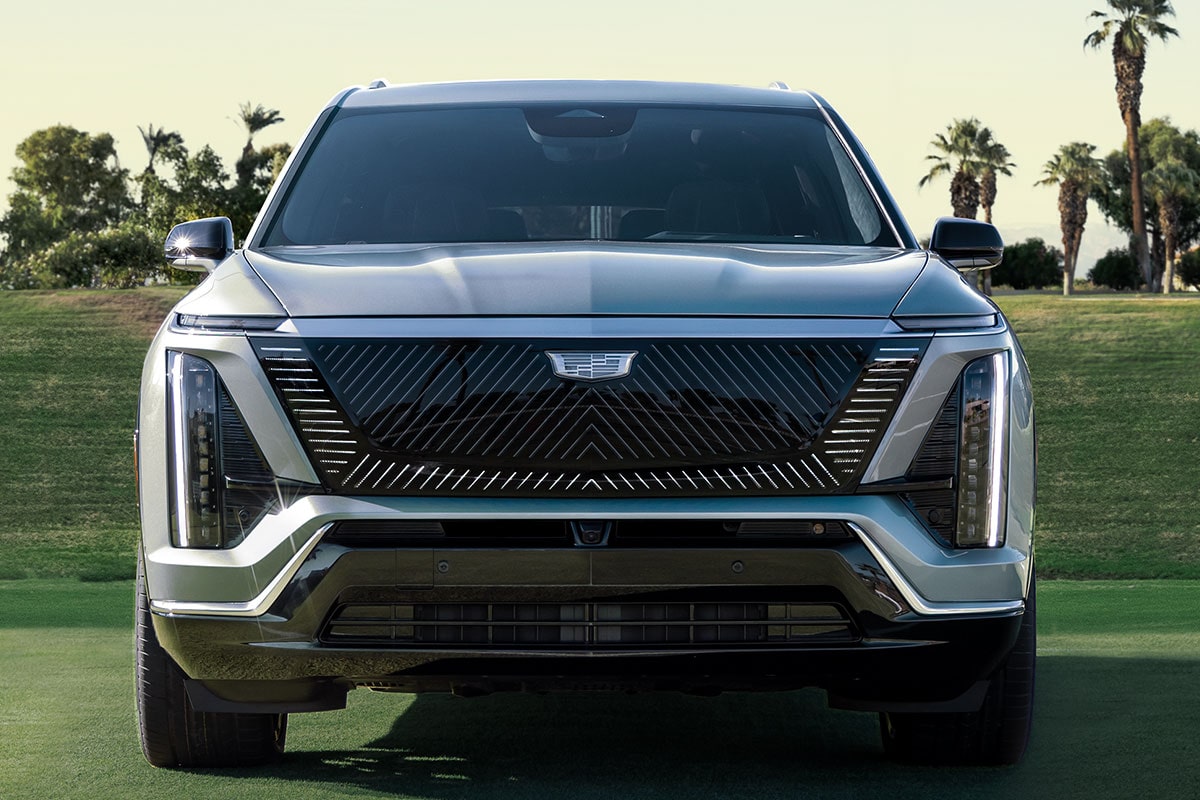 Front View of a 2027 VISTIQ 3-row Electric SUV Parked in a Grassy Tennis Court