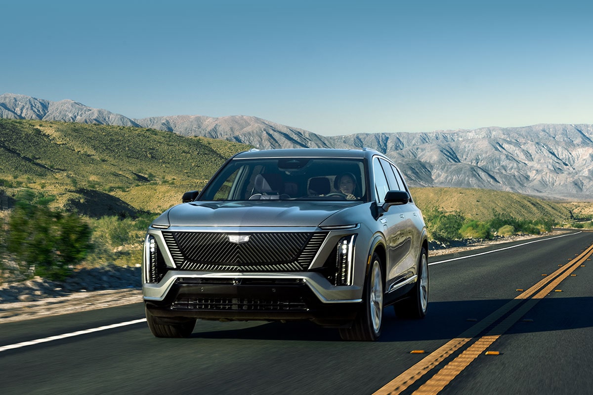 The Cadillac VISTIQ 3-row Electric SUV Driving Down a Road in the Mountains