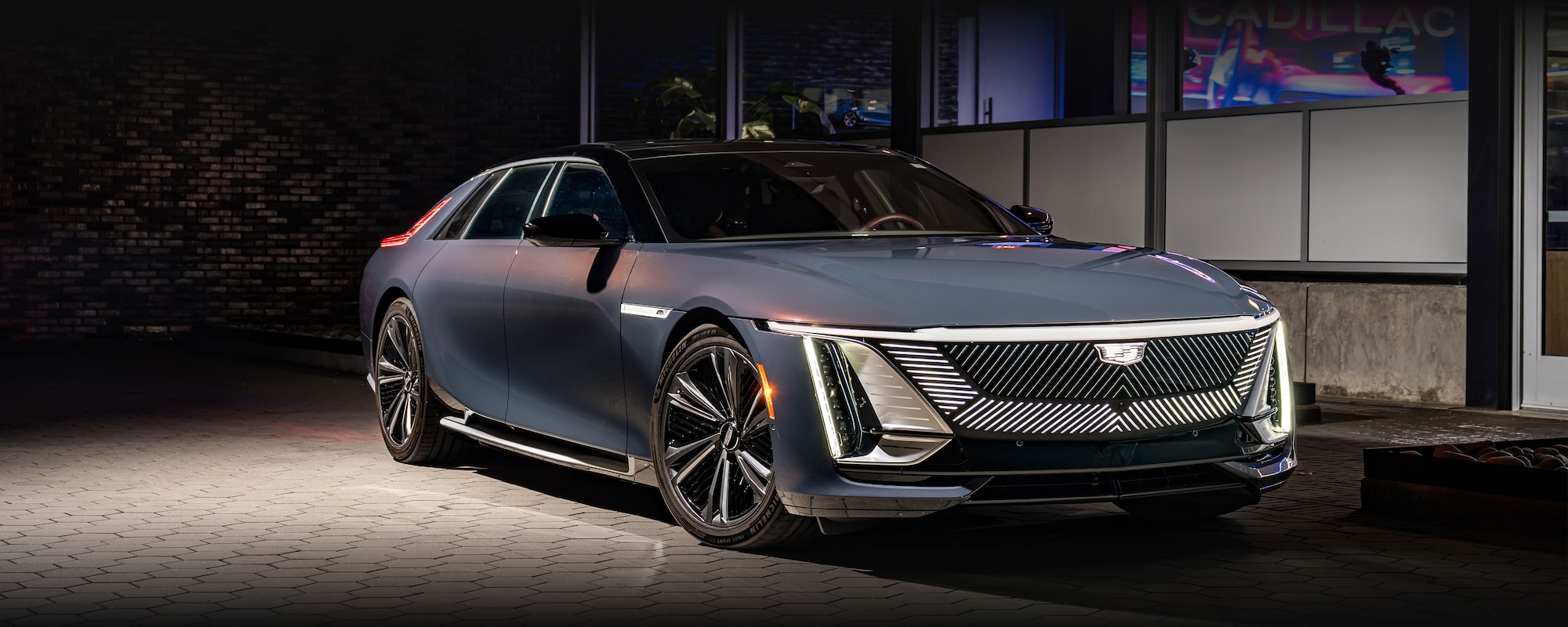 The Front of a Dark Blue Cadillac CELESTIQ at Night, Featuring an Illuminated Grille and Headlights.