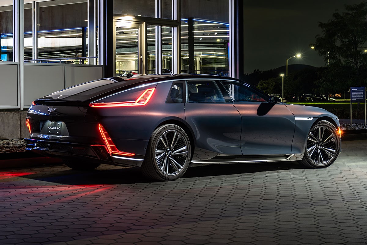 A Rear-Side View of a Dark Blue Cadillac CELESTIQ Luxury Electric Vehicle Parked at Night, Displaying Distinctive Illuminated Taillights.
