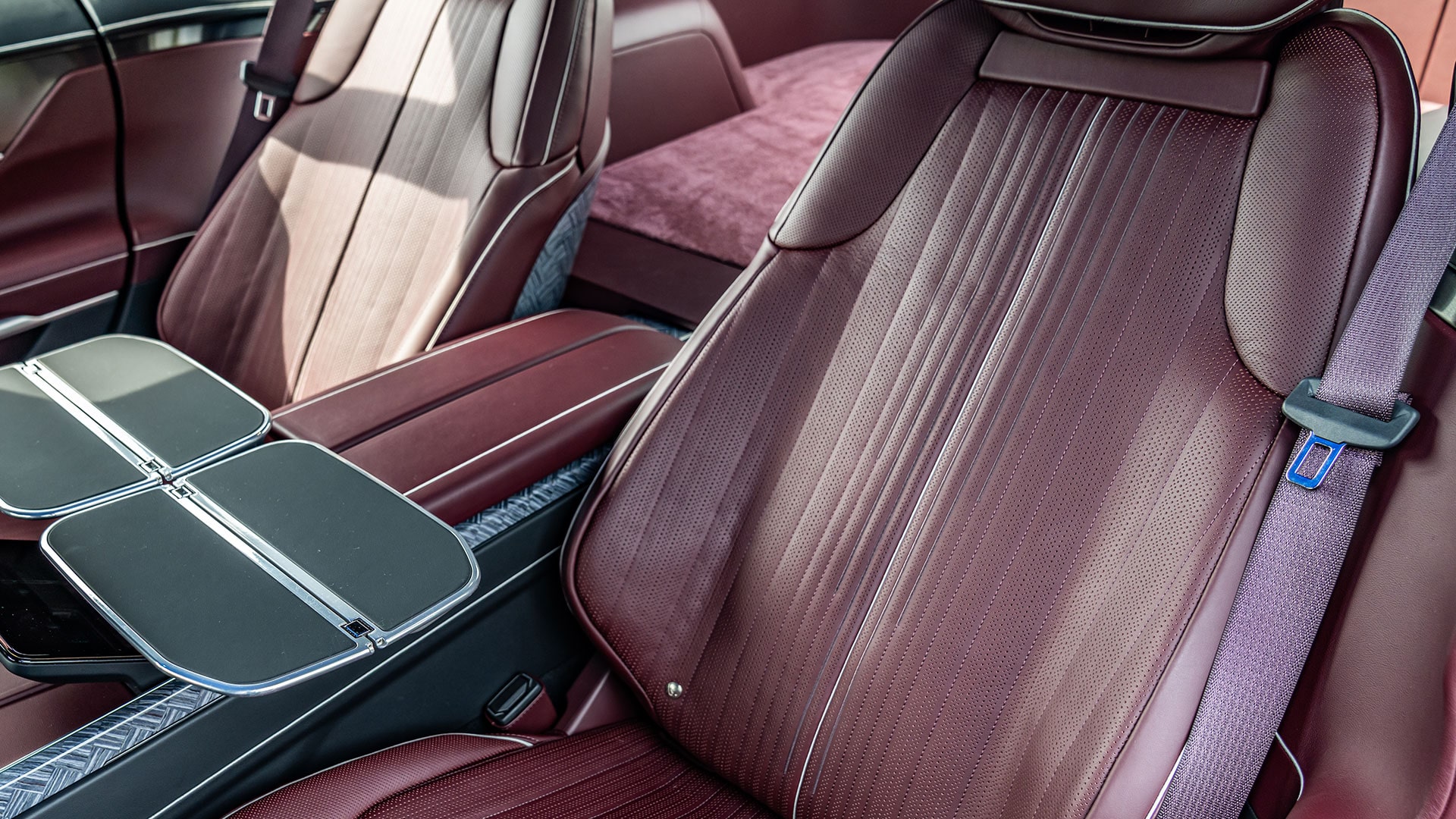 The Cadillac CELESTIQ Rear Passenger Area, Featuring Foldable Tray Tables and Brown Leather Seats.