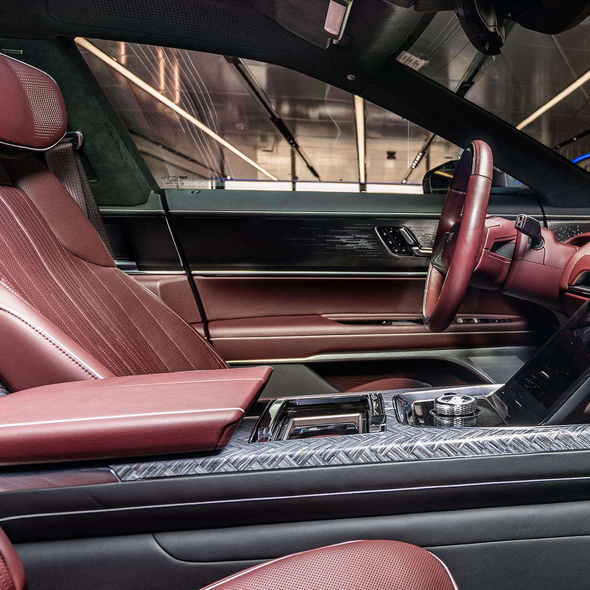 The Luxurious Interior of the Cadillac CELESTIQ With Dark Red Leather Seats and a Patterned Console.
