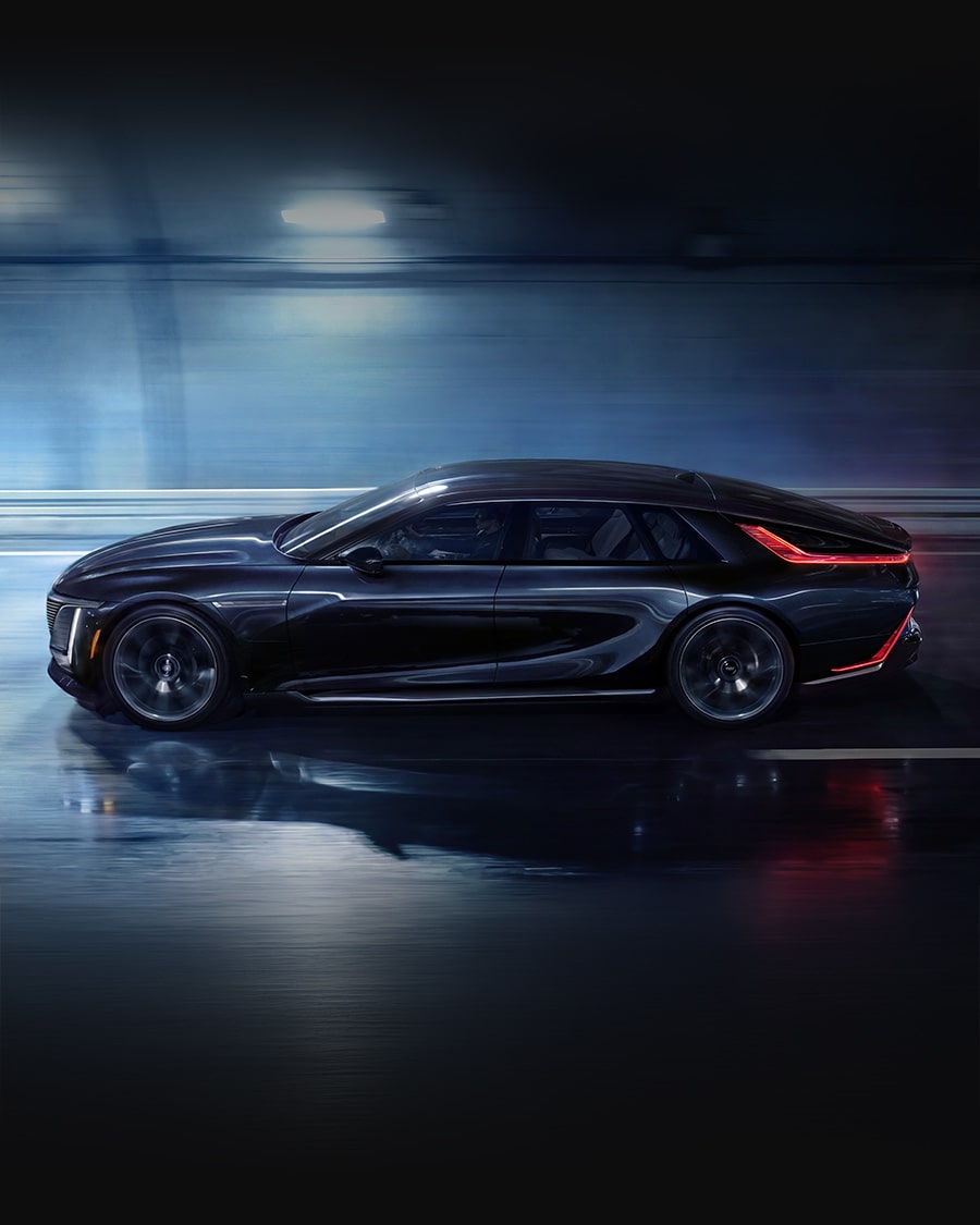 A Black Cadillac CELESTIQ Luxury Sedan in Motion at Night, Shown in Profile With Illuminated Vertical Lighting and a Continuous Rear Light Signature Against a Blurred Urban Backdrop.