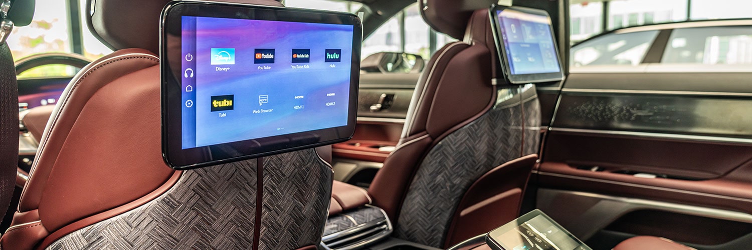 A View of the Rear Seats in the Cadillac CELESTIQ, Featuring Brown Leather, Textured Seatbacks, and Dual Infotainment Screens Displaying App Icons.