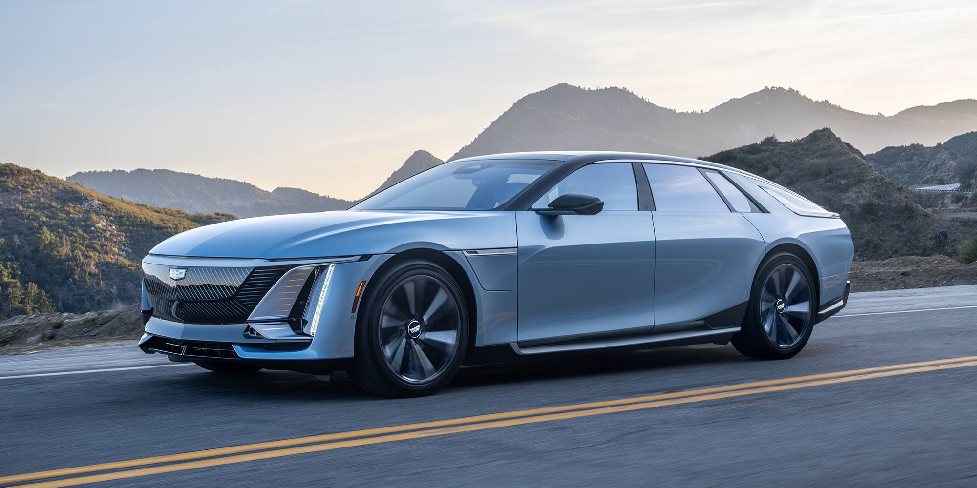 A White Cadillac CELESTIQ Luxury Sedan Parked Along a Scenic Mountain Road With a Dramatic Landscape in the Background.