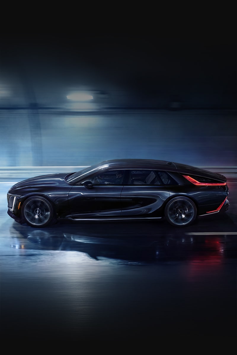 A Rear Three-Quarter View of a Black Cadillac CELESTIQ Driving on a Wet Road at Night With Illuminated Vertical Taillights, Reflective Pavement, and Dynamic Motion Blur.