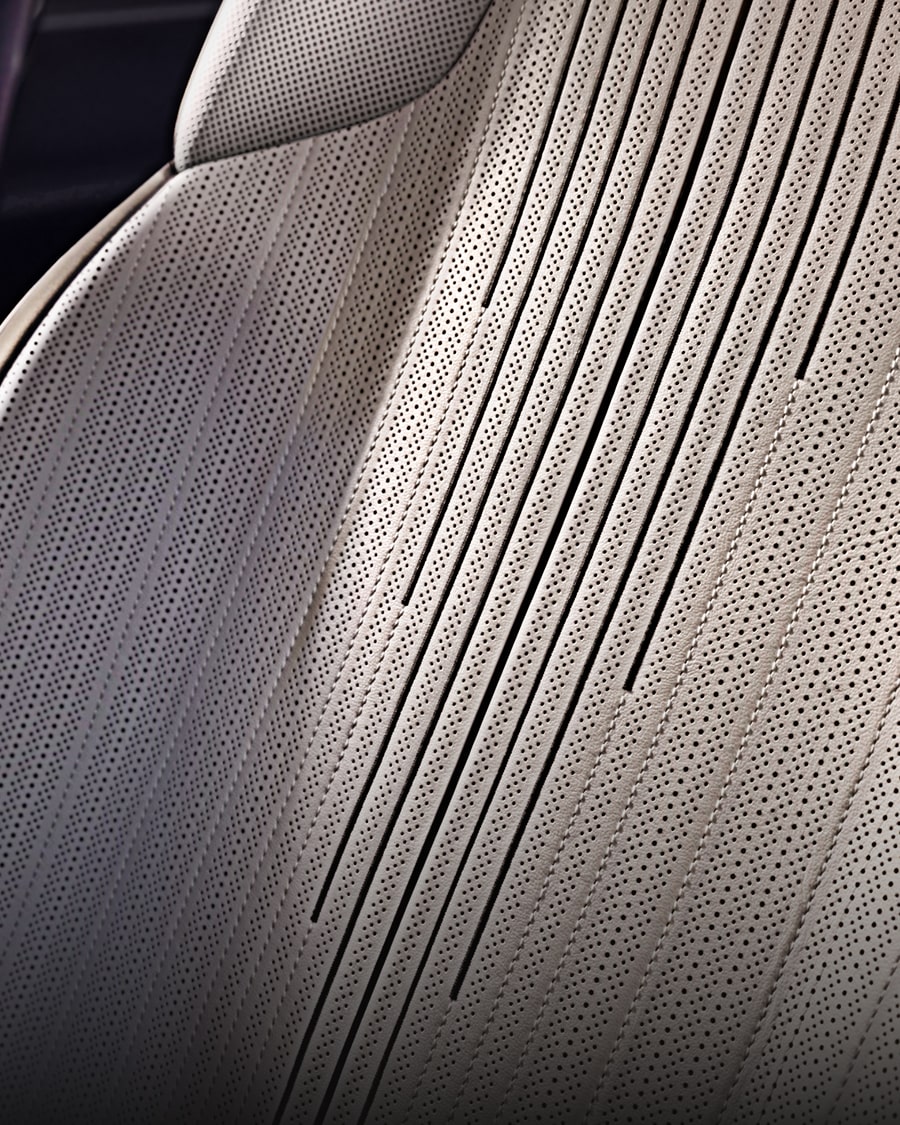 A Close-Up View of a Cadillac CELESTIQ White Leather Seat Showcasing Perforated Upholstery, Intricate Stitching, and Vertical Pleat Detailing.
