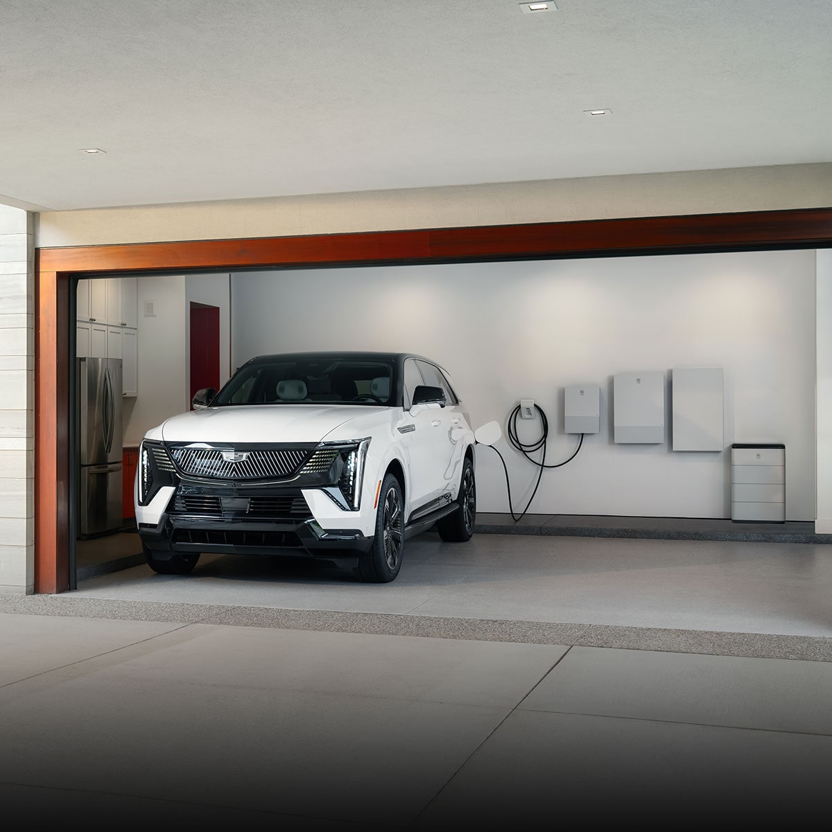A White Cadillac EV Parked in a Garage Charging with a GM Energy Home System