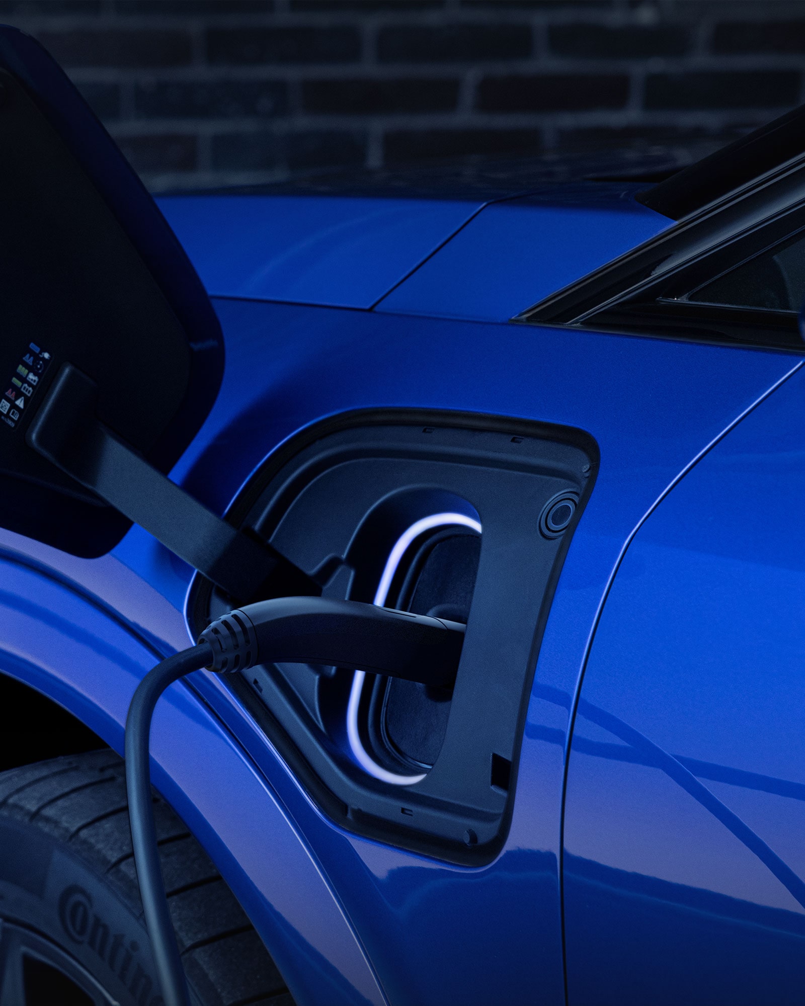 Close-up of a Charger Plugged into a Blue Cadillac EV's Charging Port