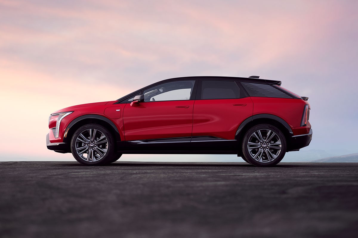 A Side Profile of a Red Cadillac OPTIQ During Dusk