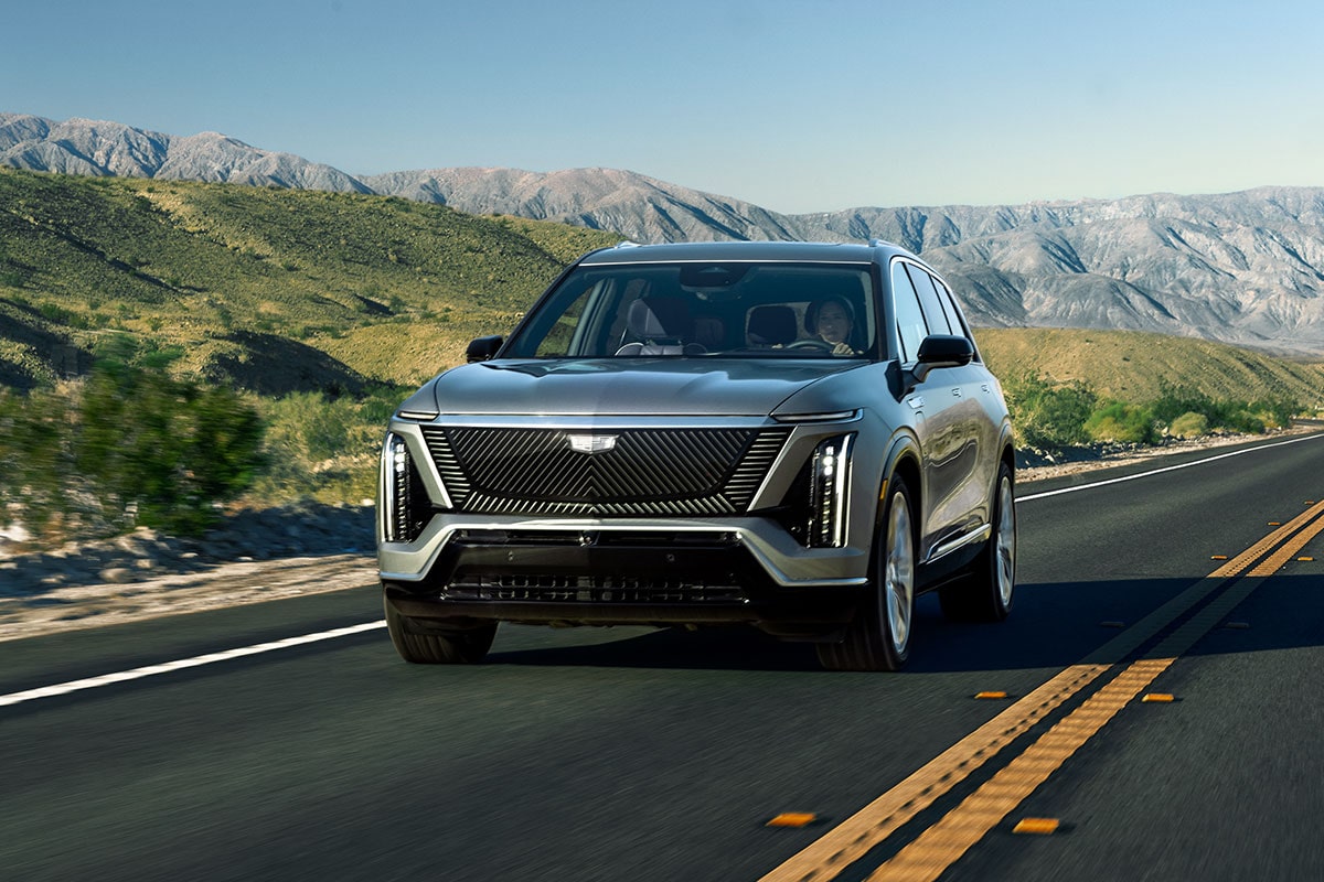 A Cadillac VISTIQ All-electric SUV Driving Down a Road in the Mountains