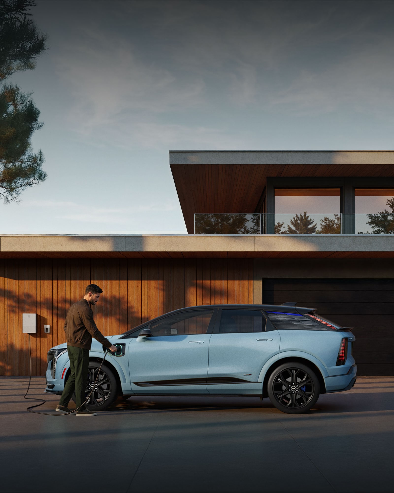 A Man Plugging in a EV Charger into a Baby Blue Cadillac OPTIQ-V Outside of a Modern Home
