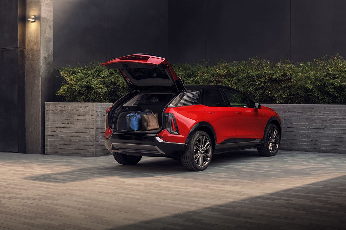 A Red Cadillac OPTIQ Parked with the Tailgate Open and the Spacious Trunk Filled with Cargo