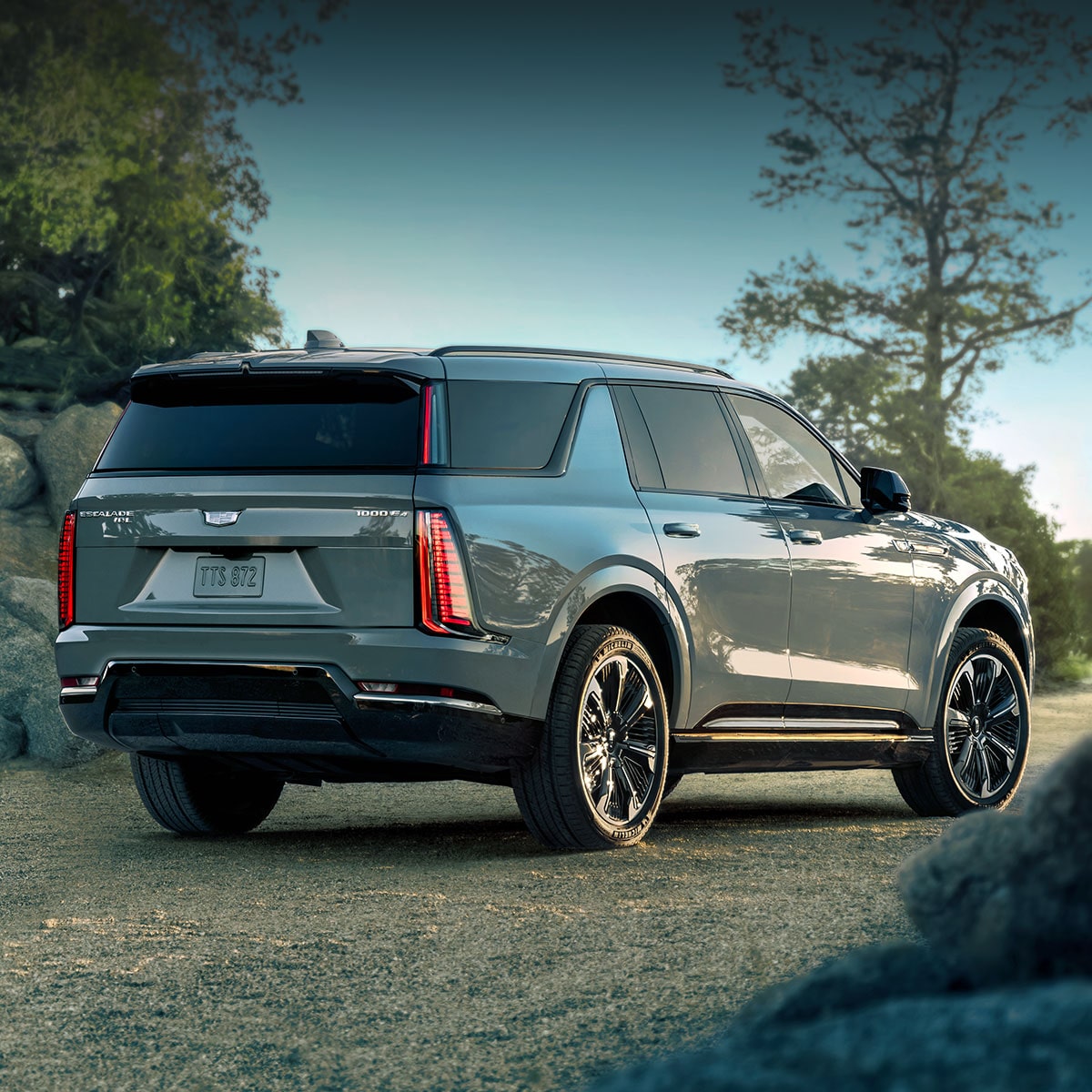 The Cadillac VISTIQ, LYRIQ, and OPTIQ Electric SUVs Lined Up Next to Eachother During a Beautiful Sunset