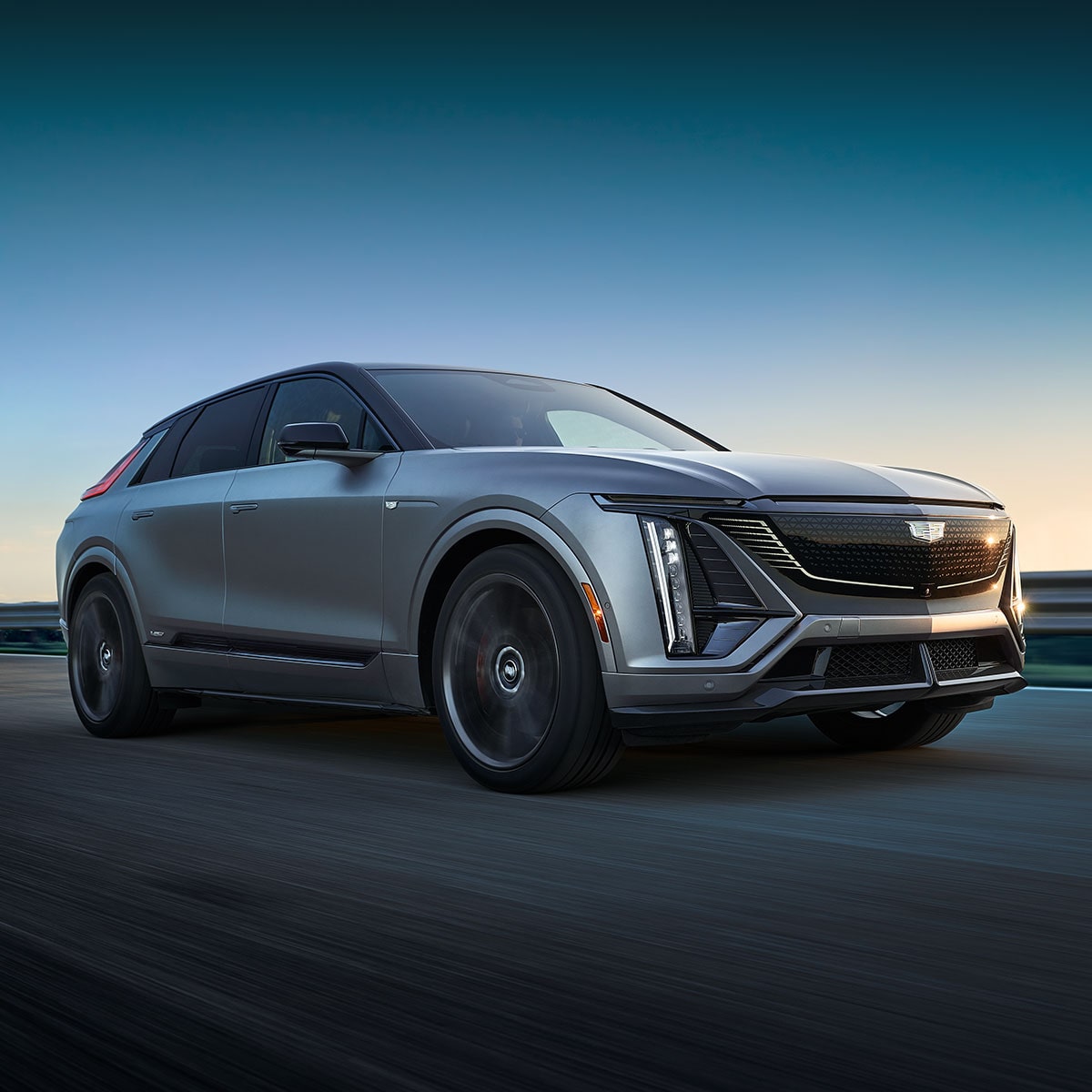 The Cadillac VISTIQ, LYRIQ, and OPTIQ Electric SUVs Lined Up Next to Eachother During a Beautiful Sunset