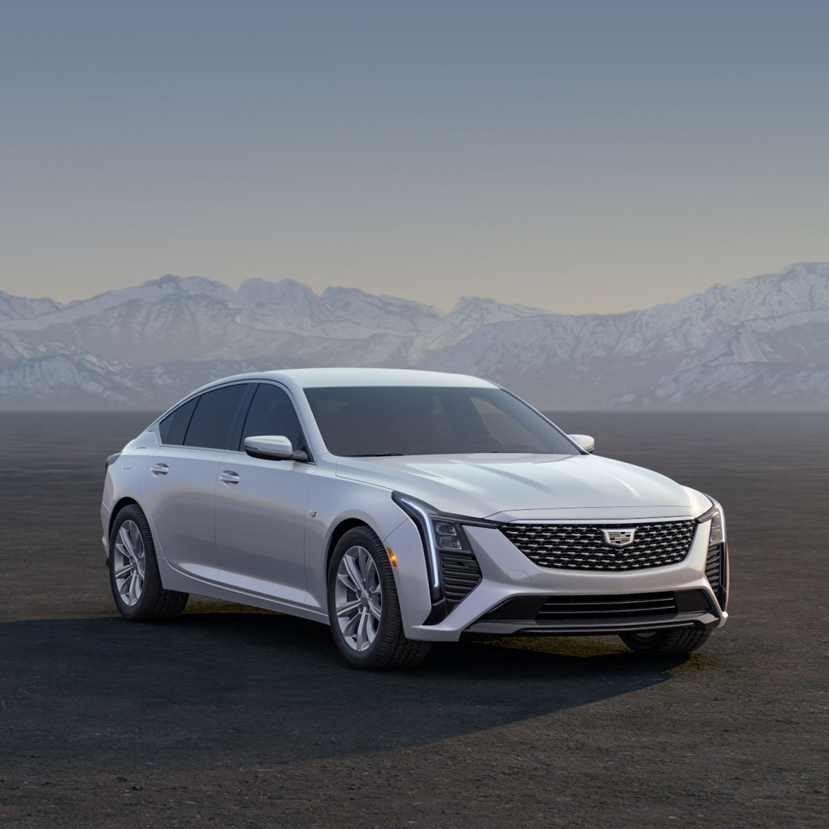 Three Cadillac Silver SUVs Parked on an Open Plain at Sunrise with  Mountains in the Background