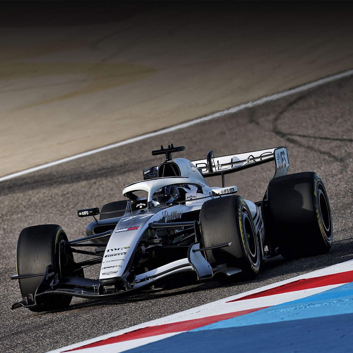 Two women seated in white armchairs wearing brightly colored clothing