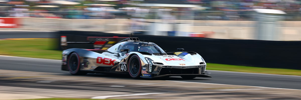 Three-Quarters View of the Blue Cadillac V-Series.R Race Car Speeding Around the Curve of a Track