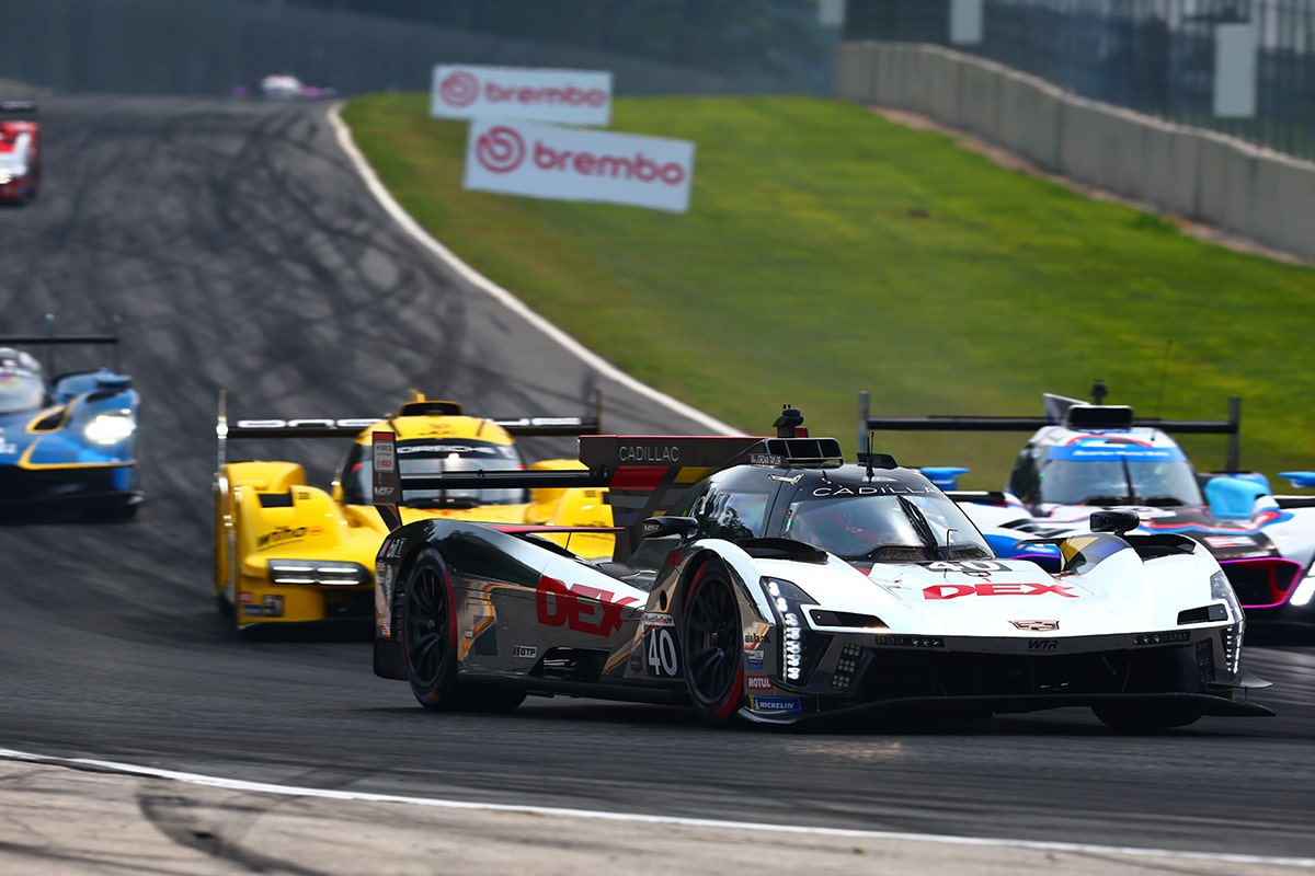 A Cadillac V-Series.R Race Car Parked in the Pit Stop While the Team Rushes to Change Tires