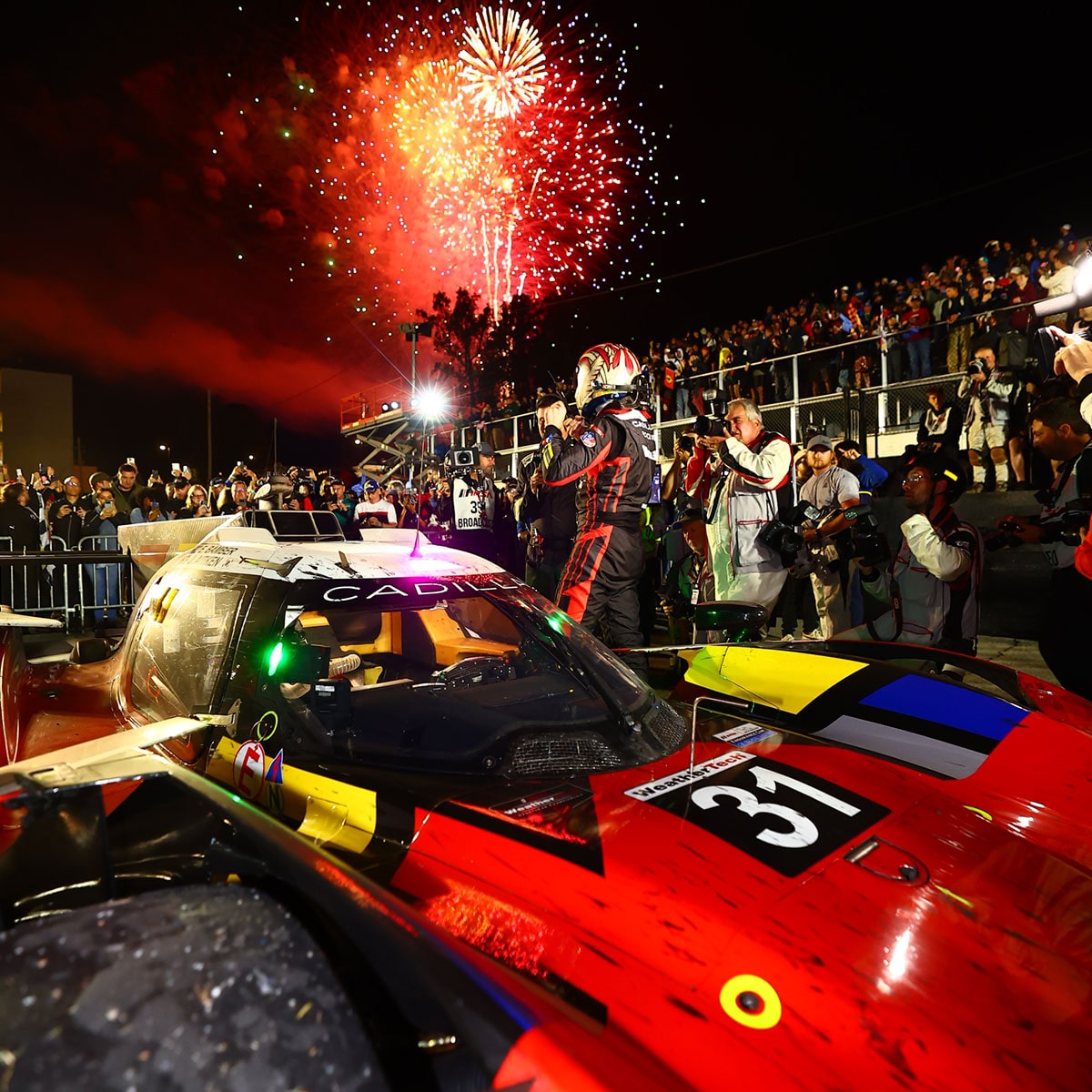 Front View of the Red Cadillac V-Series.R Race Car Driving on the Curve of a Track