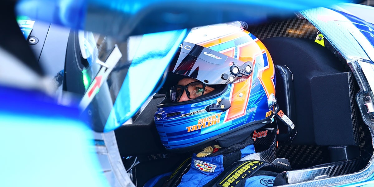 Side View of a Race Car Driver Wearing a Helmet in a Cadillac Race Car
