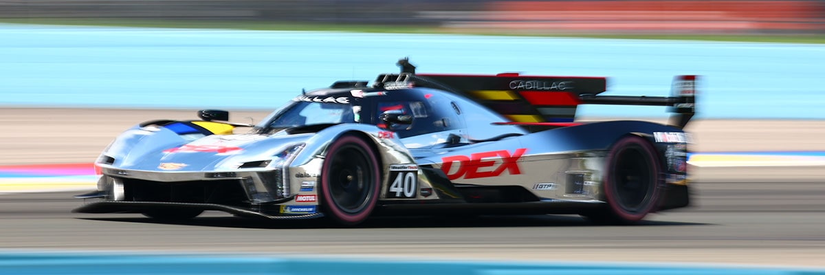 Side View of a Cadillac Race Car Speeding Around the Race Track
