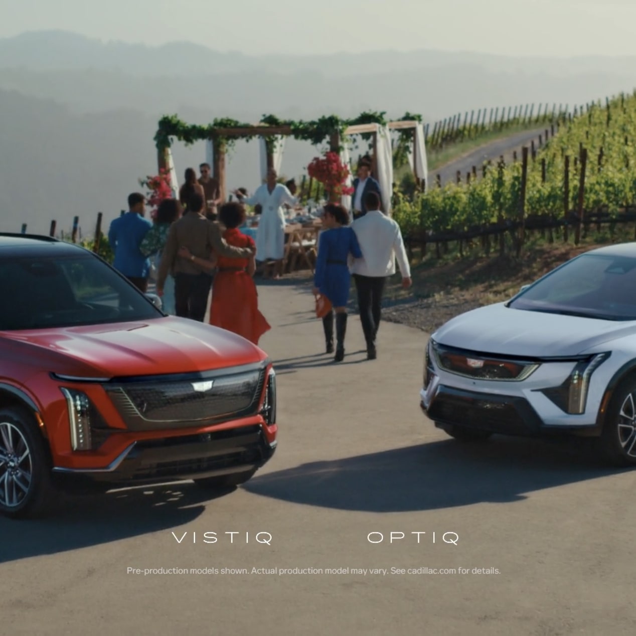 The Cadillac VISTIQ and OPTIQ Parked in Front of People Walking Towards a Wedding Ceremony Under a Beatuiful Pergola on a Vineyard