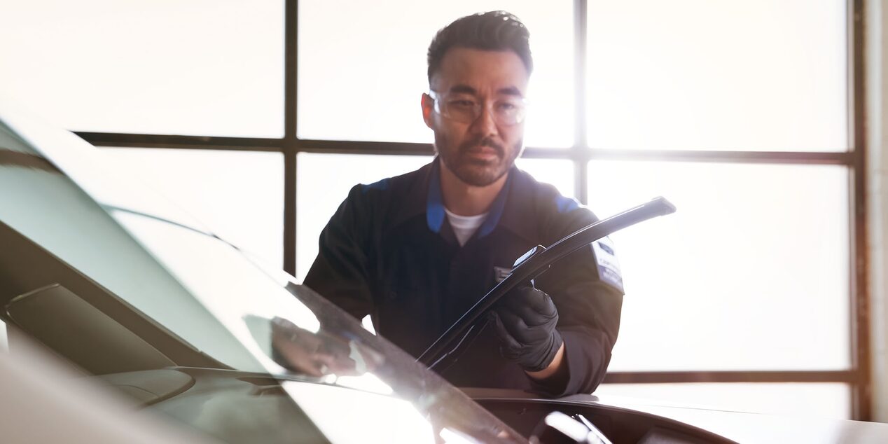 Técnico de Cadillac instalando nuevos limpiaparabrisas en un vehículo