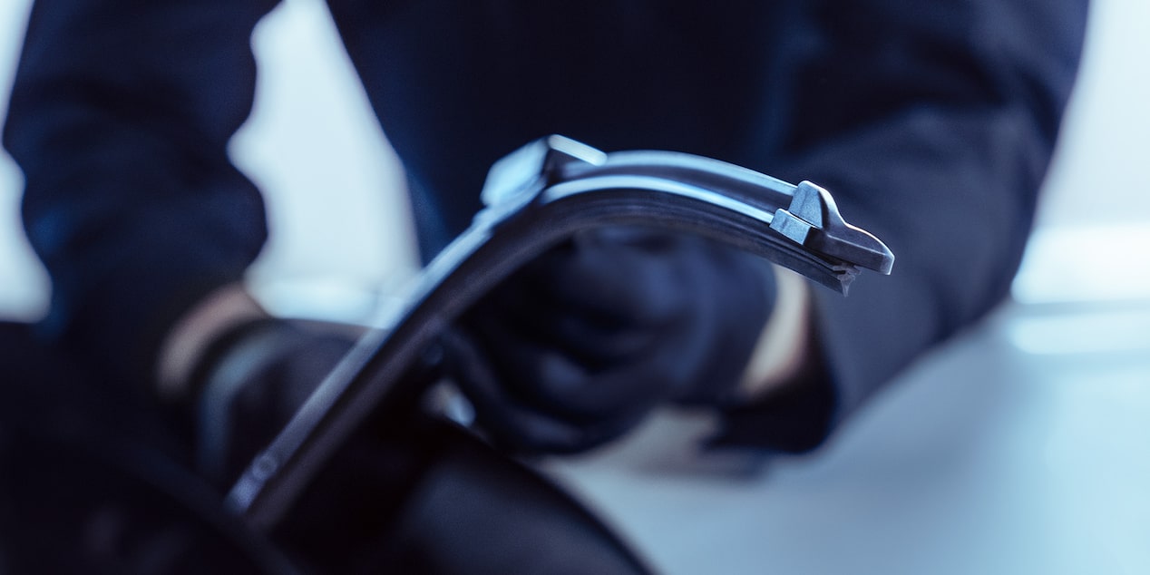 A Mechanic Is Seen Inspecting a Windshield Wiper
