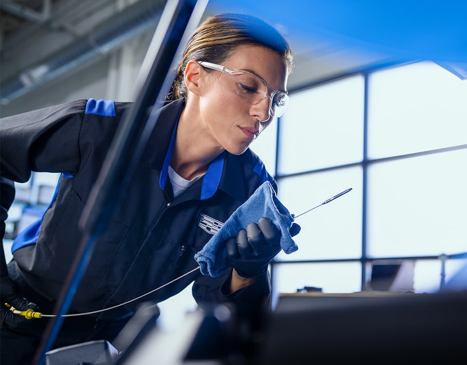 Cadillac Certified Service Technician Inspecting an Oil Dipstick During an Oil Change Service