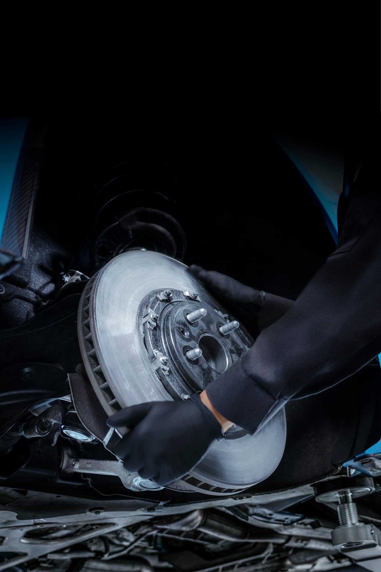 Técnico de servicio certificado de Cadillac reemplazando un rotor de freno en un vehículo