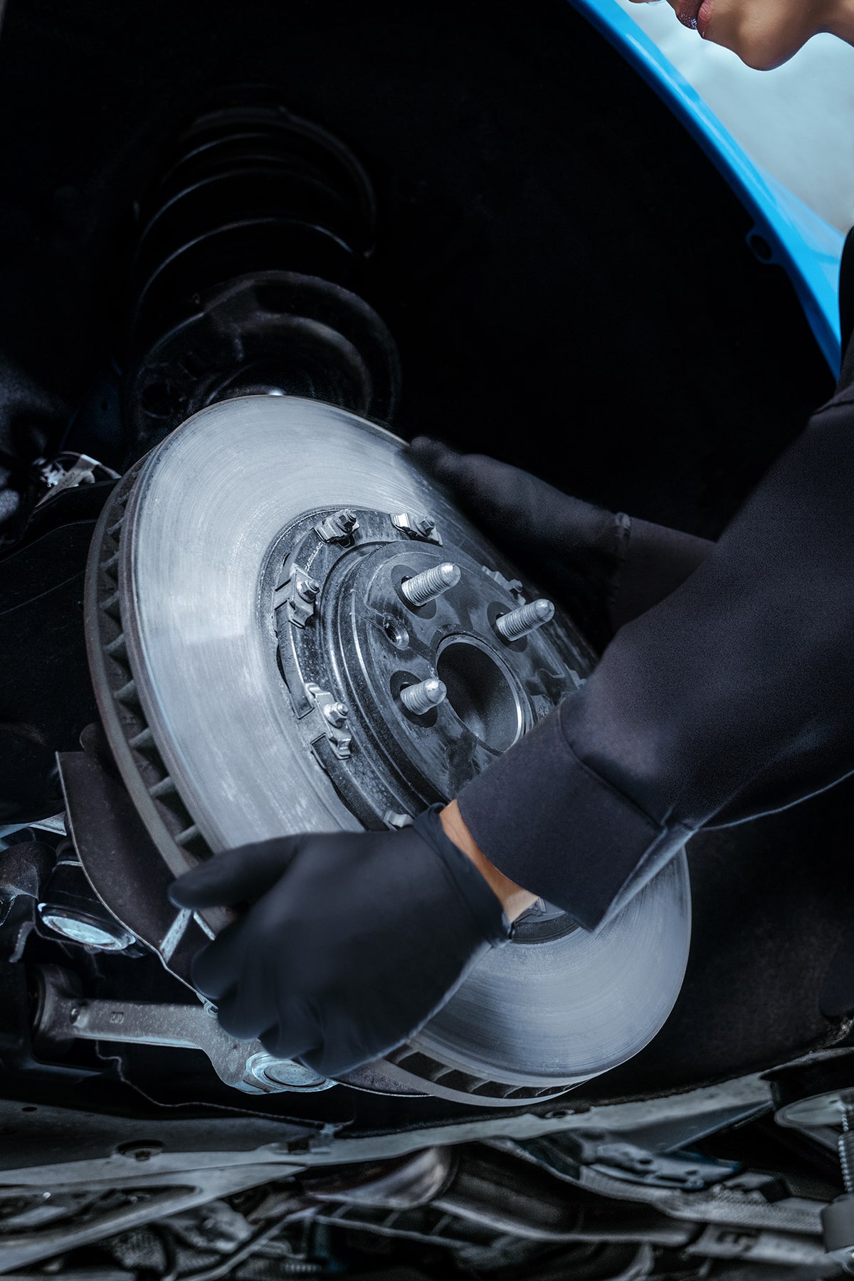 Técnico de servicio certificado de Cadillac reemplazando un rotor de freno en un vehículo